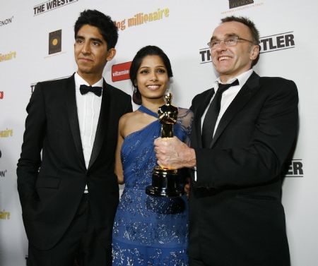 Director Danny Boyle (R) holds his Oscar for Best Director for "Slumdog Millionaire" as he poses with cast members Dev Patel (L) and Freida Pinto at the official Oscar after party for Fox Searchlight's "Slumdog Millionaire" and "The Wrestler" in Los Angeles Feb. 22, 2009. ©Reuters